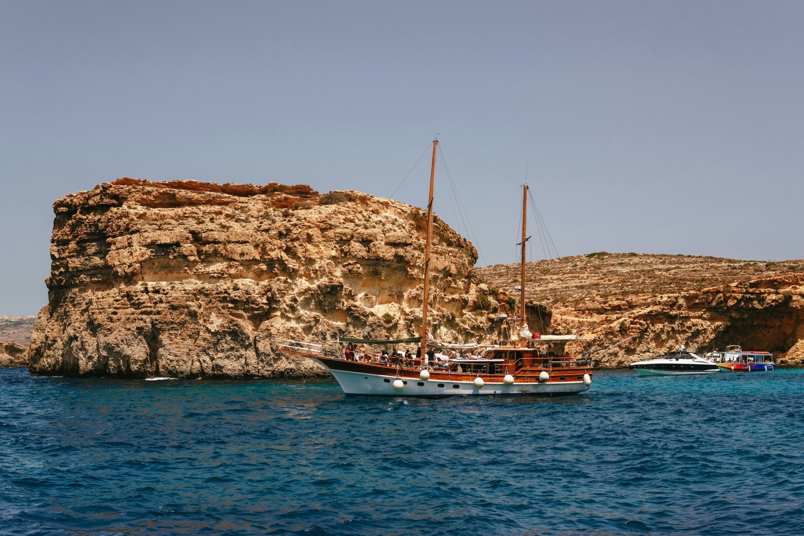 A boat in the water near a rocky island